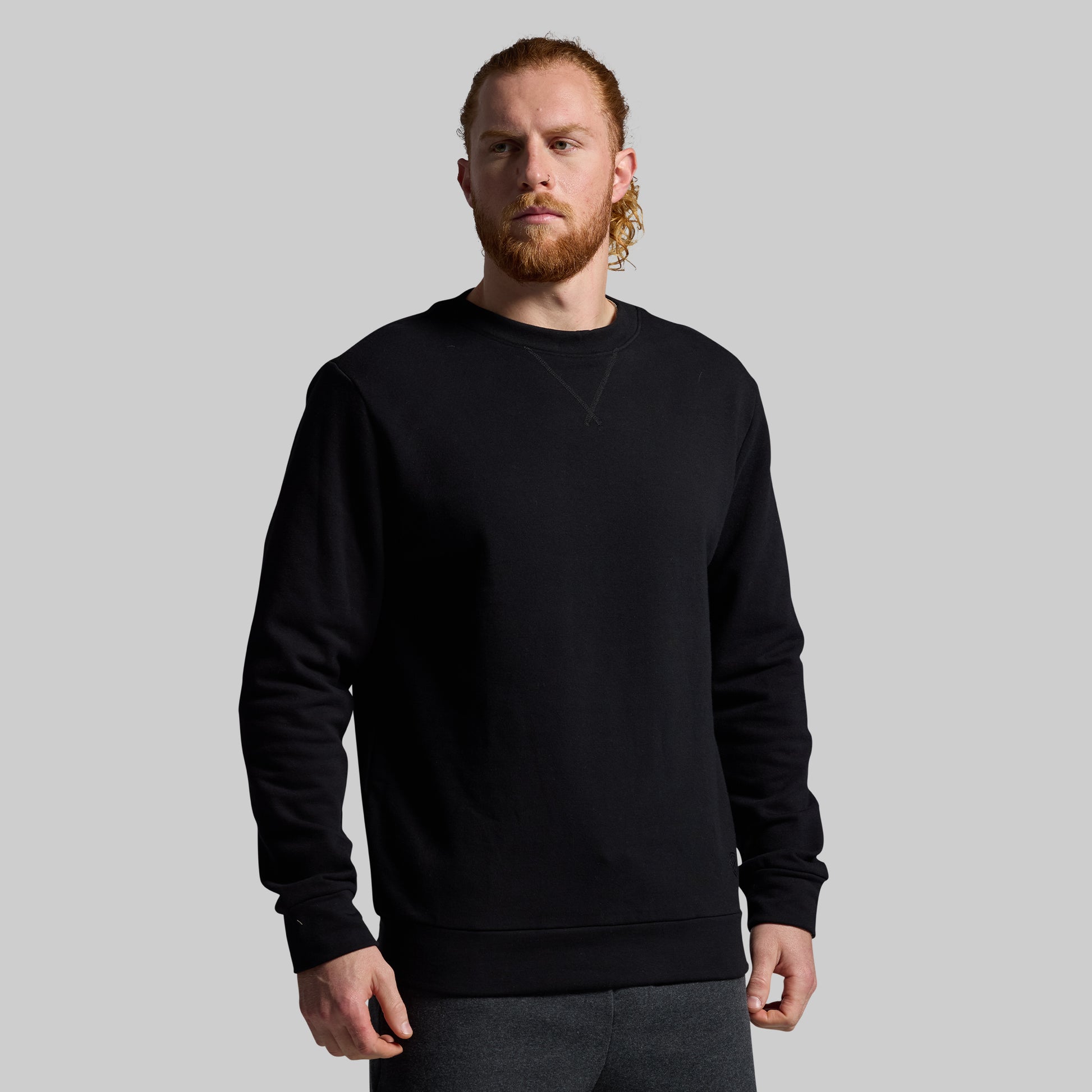 Man wearing a black sweatshirt against a plain background