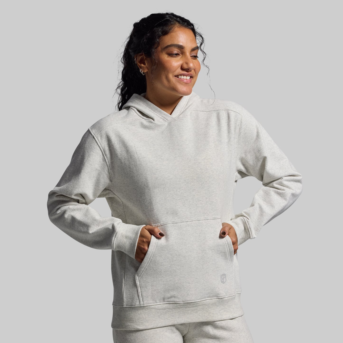 Person wearing a light gray hoodie on a plain background