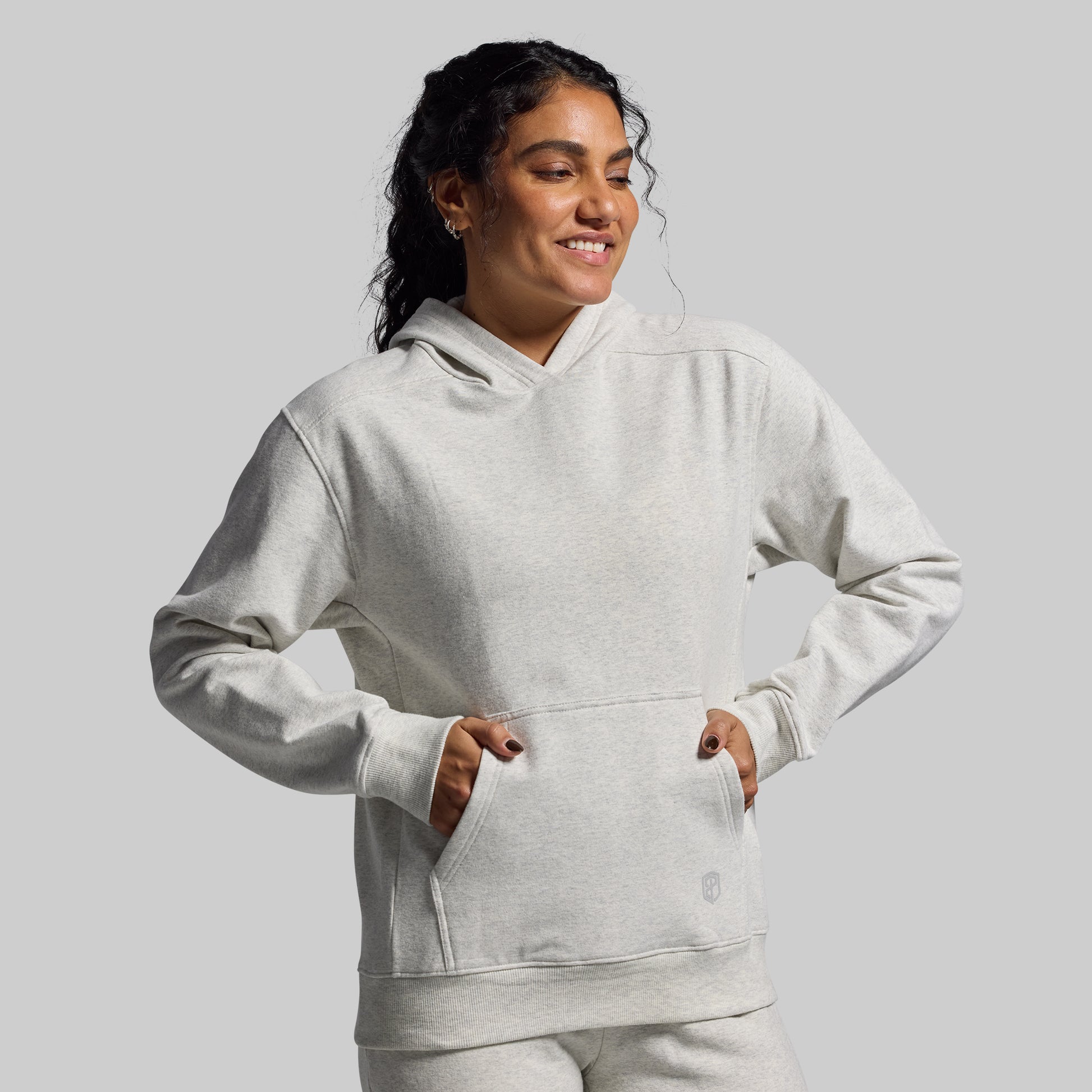 Person wearing a light gray hoodie on a plain background