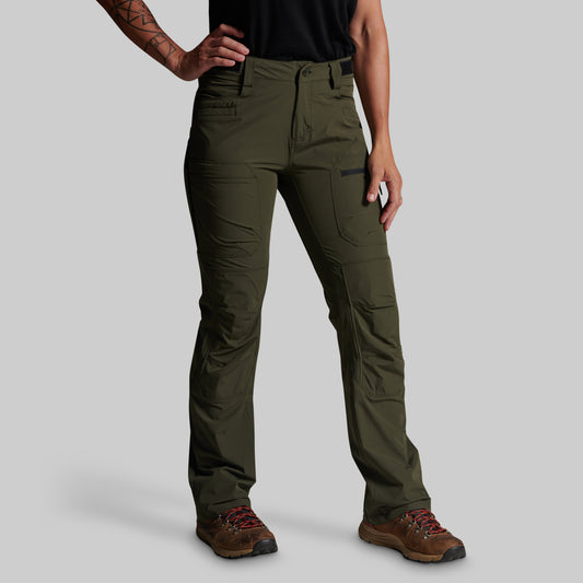 A model wearing olive green technical cargo pants with brown hiking boots, shown from the waist down against a solid gray background.