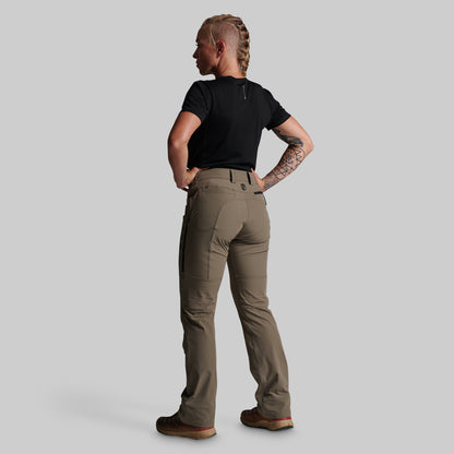 A woman shown from the back wearing a black short-sleeve t-shirt and storm grey cargo pants, standing against a solid gray studio background.