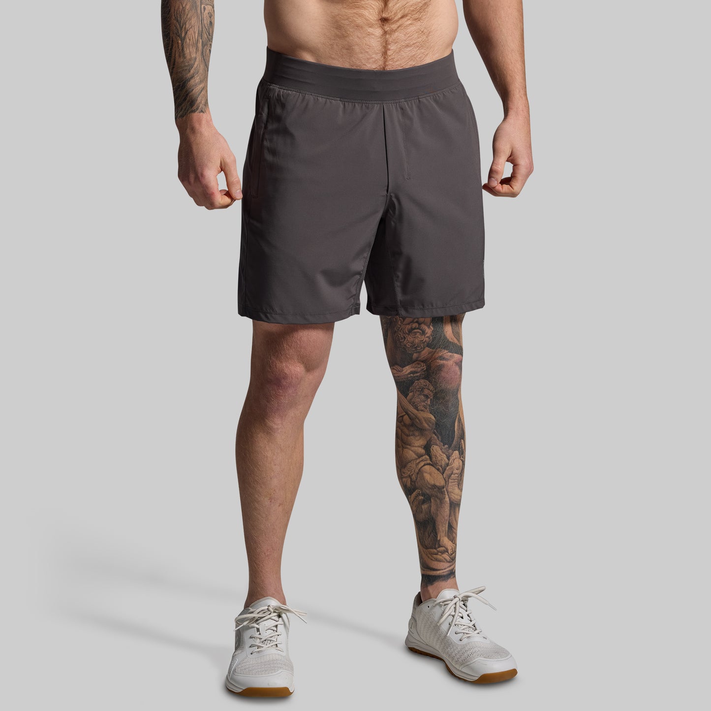 Person wearing gray shorts on a plain background