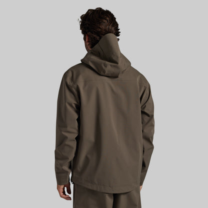 Man wearing the Ranger Green Mission FLEX Rain Jacket 2.0, back view