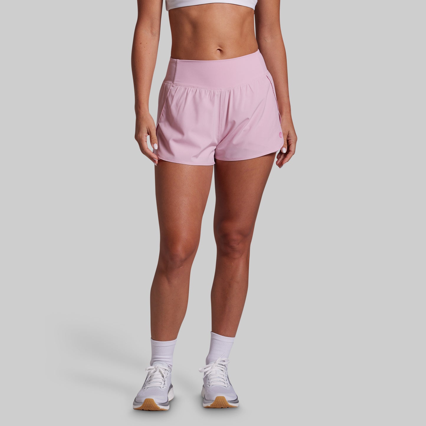 Person wearing pink shorts on a plain background