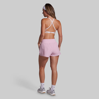 Woman wearing a pink athletic outfit on a gray background