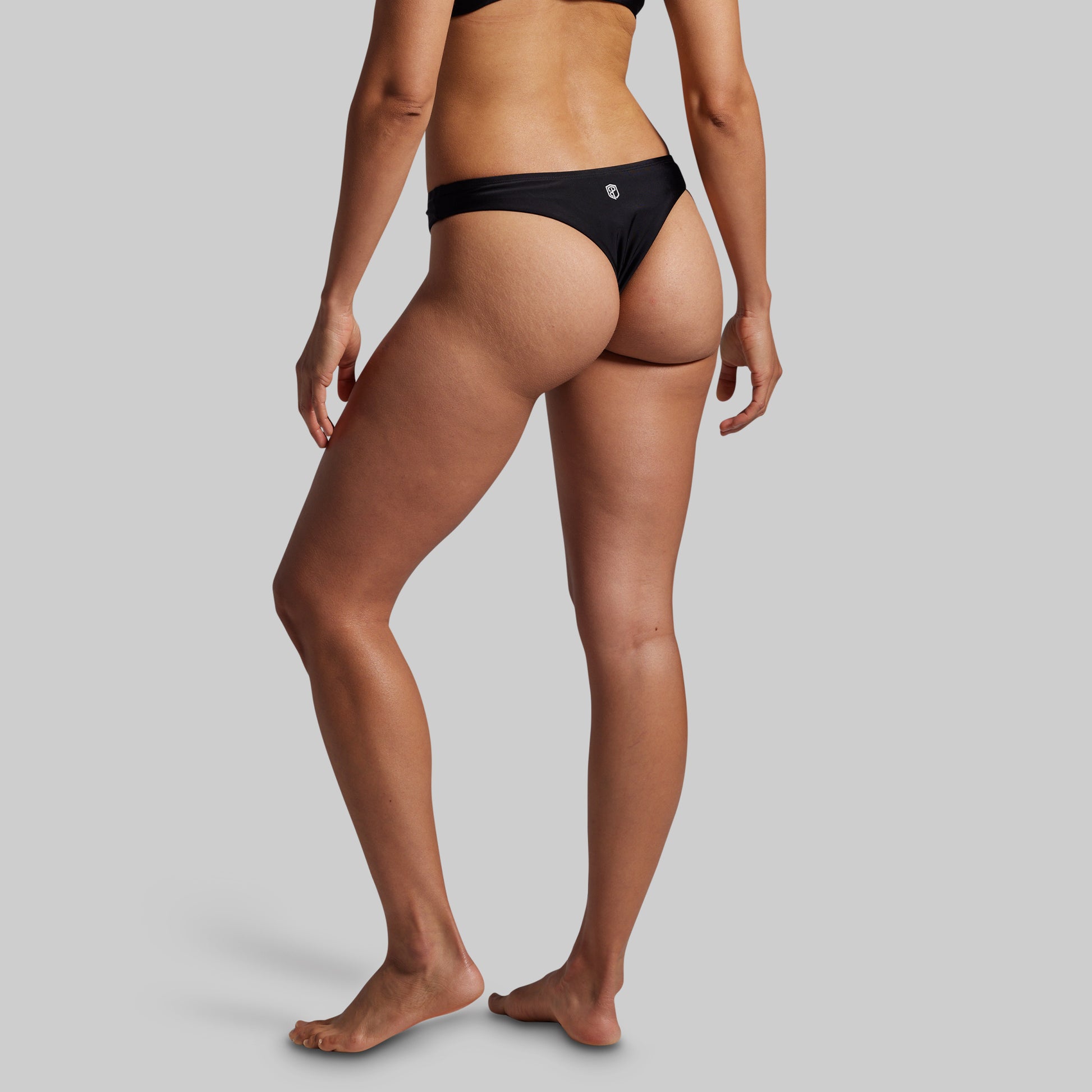 Person wearing a black bikini bottom on a gray background