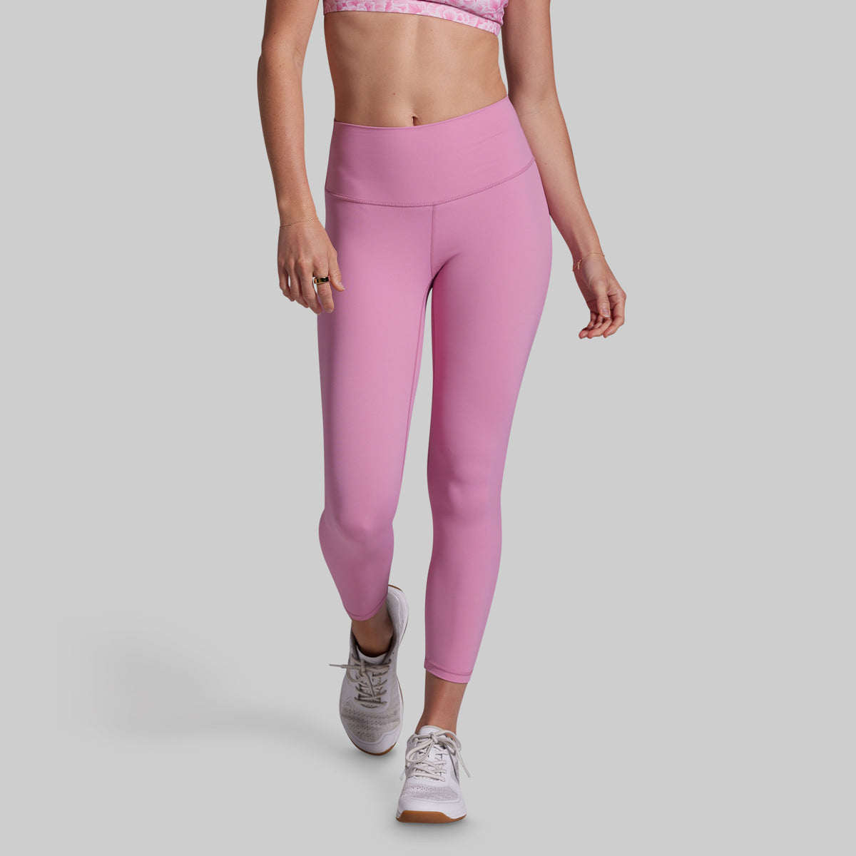 Person wearing pink leggings on a gray background