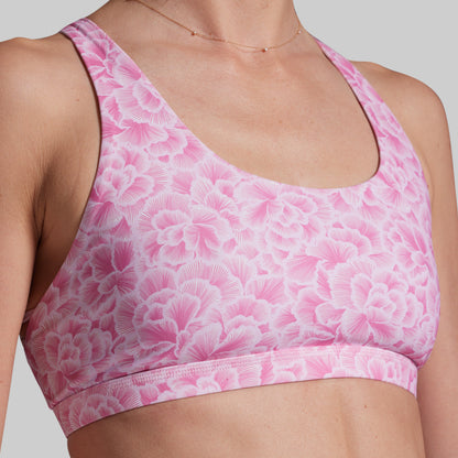Pink floral sports bra on a neutral background