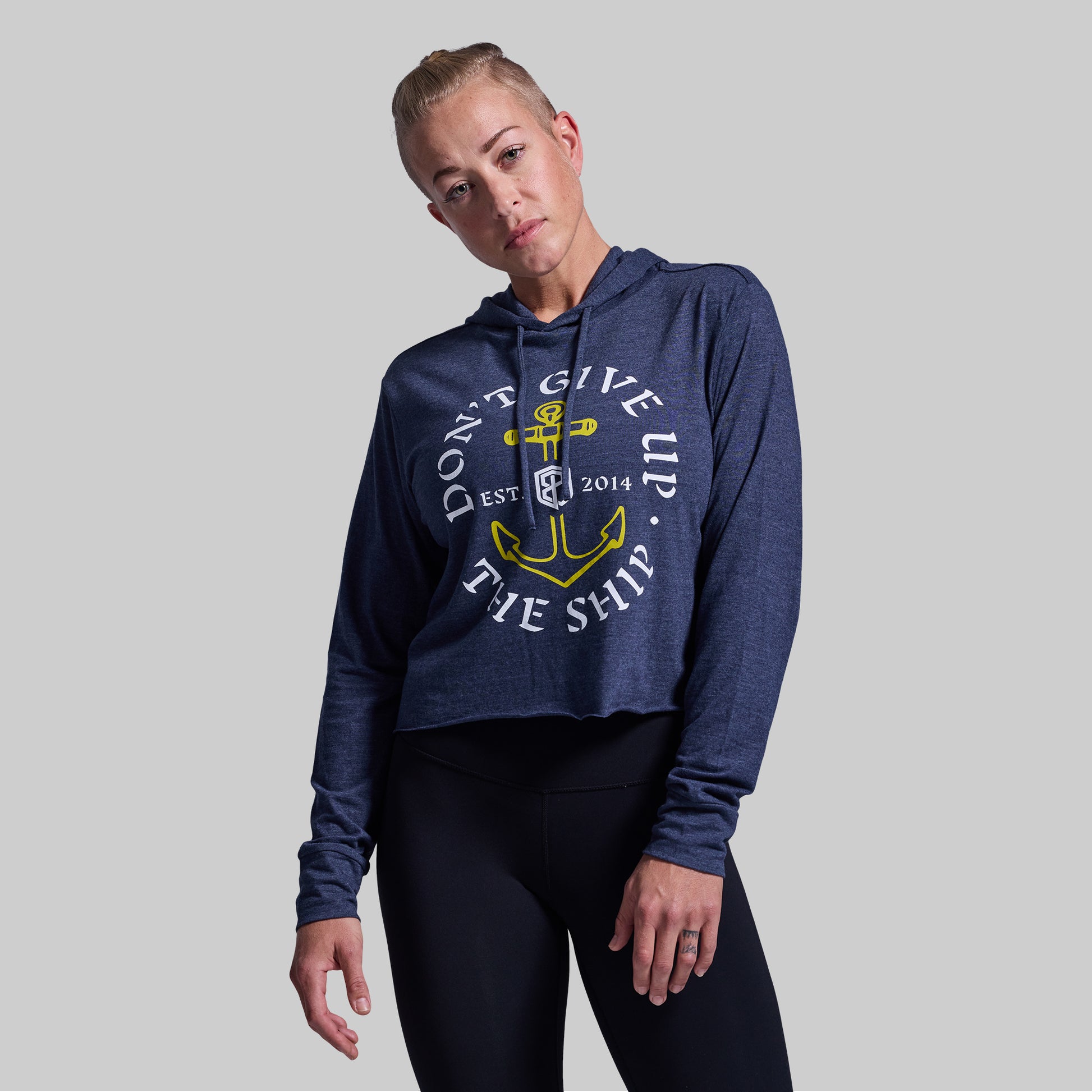 Person wearing a navy blue hoodie with a graphic design on a gray background