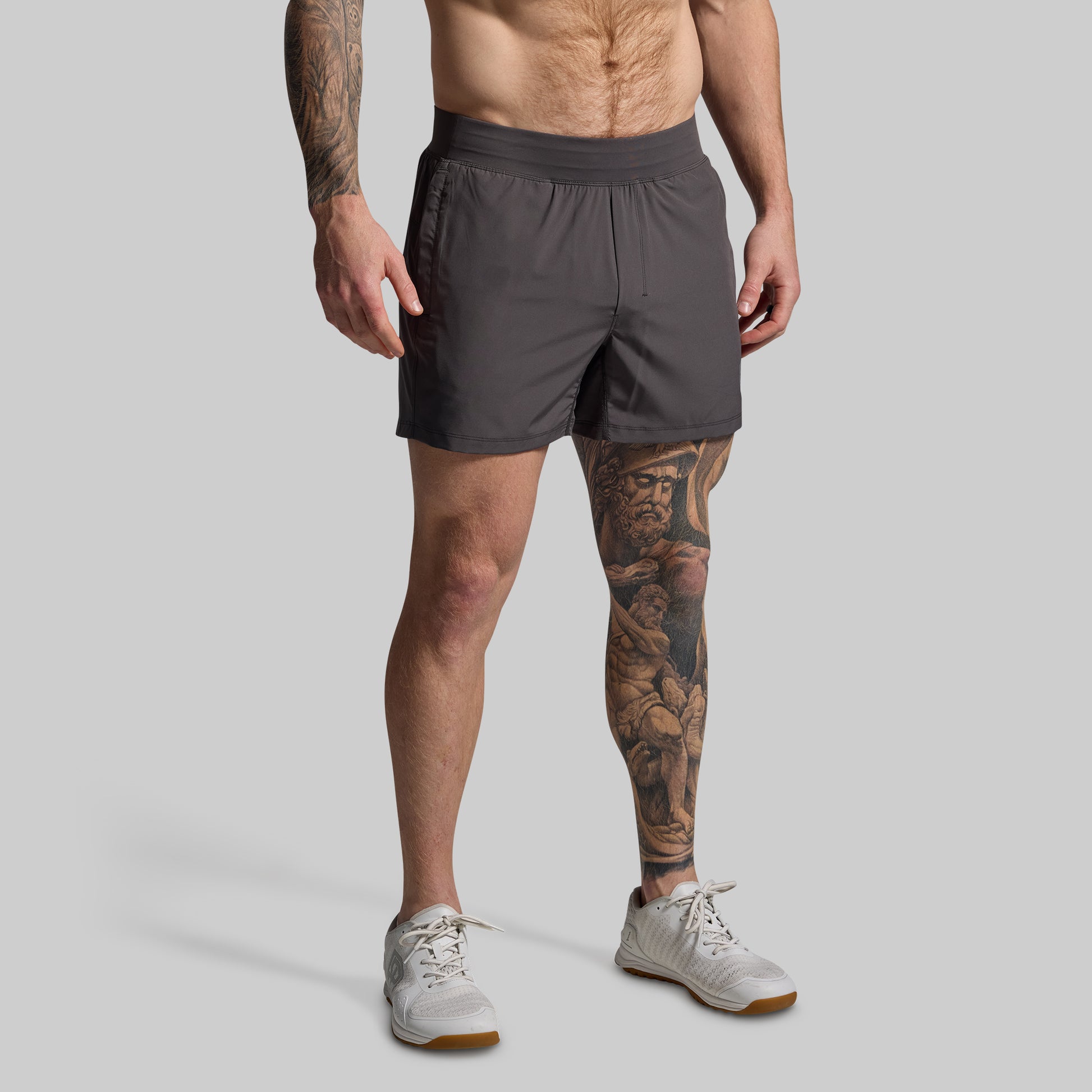 Man wearing gray shorts on a plain background