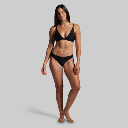 Woman wearing a black bikini against a gray background