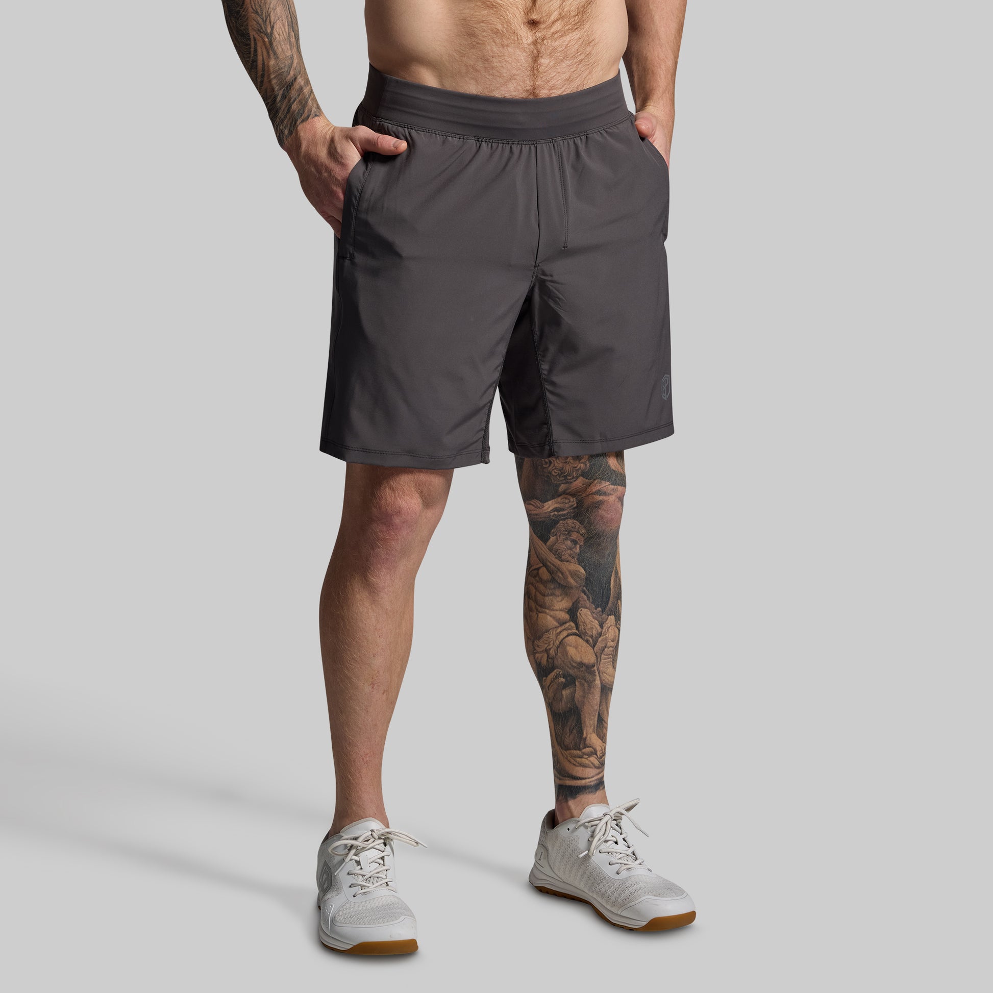 Person wearing gray shorts on a plain background