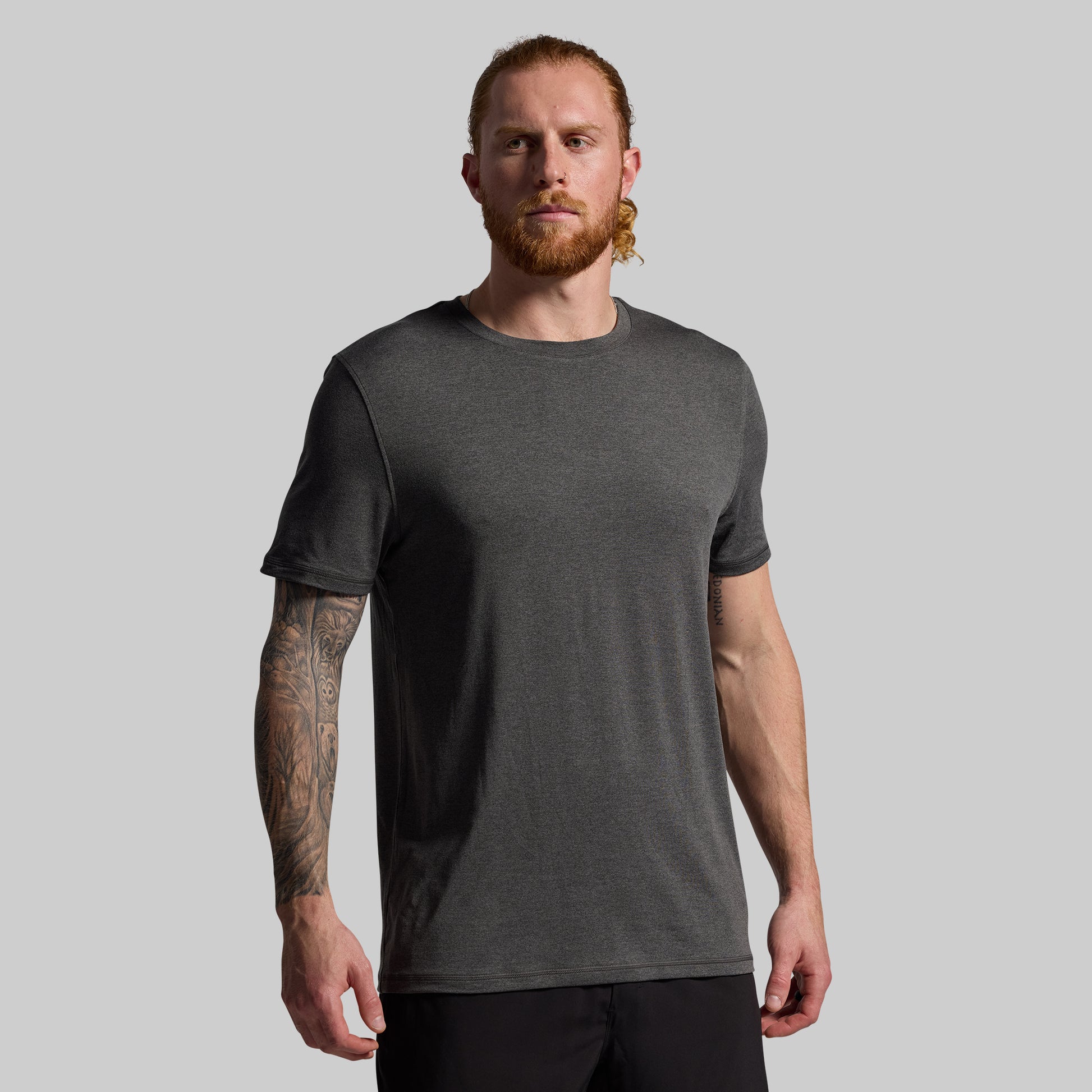 Man wearing a dark gray t-shirt against a plain background