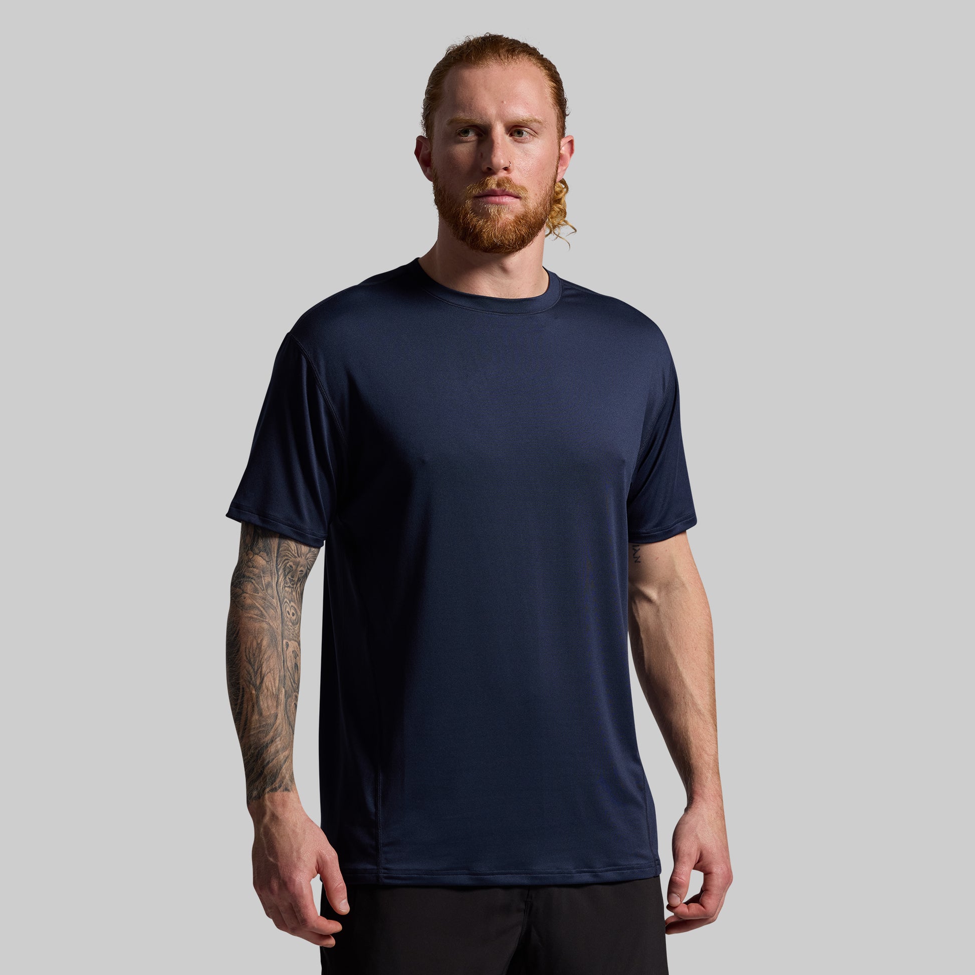 Man wearing a navy blue t-shirt against a gray background