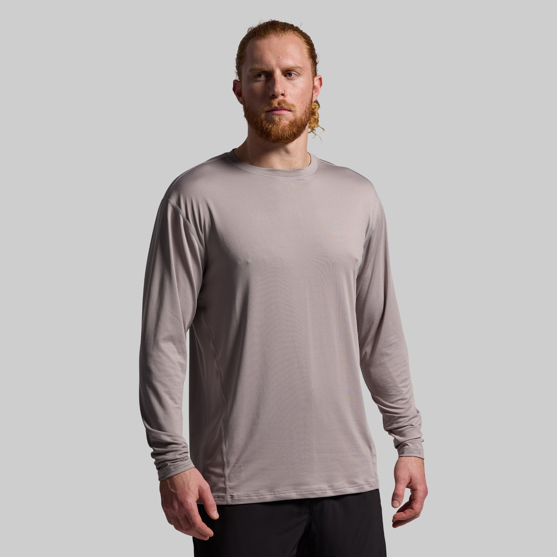Man wearing a beige long-sleeve shirt against a plain background