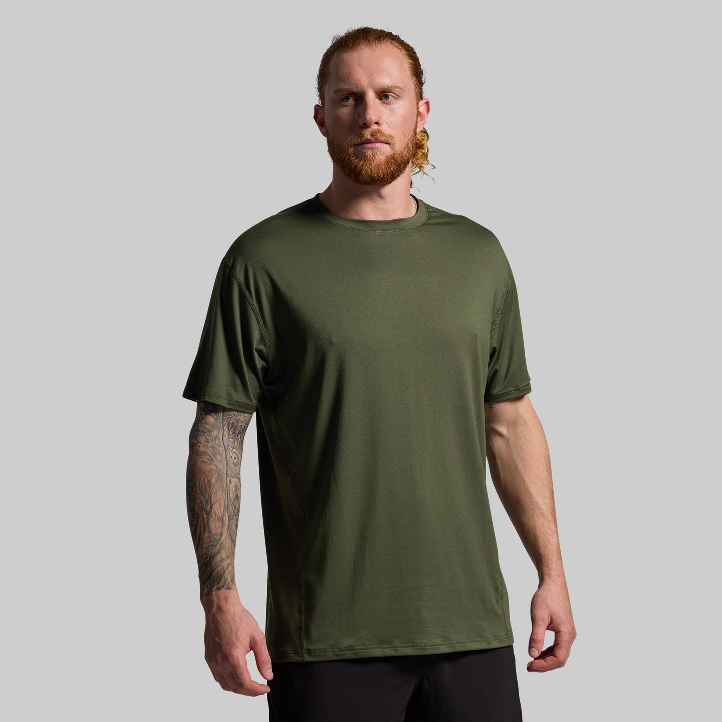 Man wearing a green t-shirt against a gray background