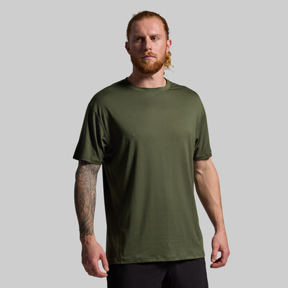 Man wearing a green t-shirt against a gray background