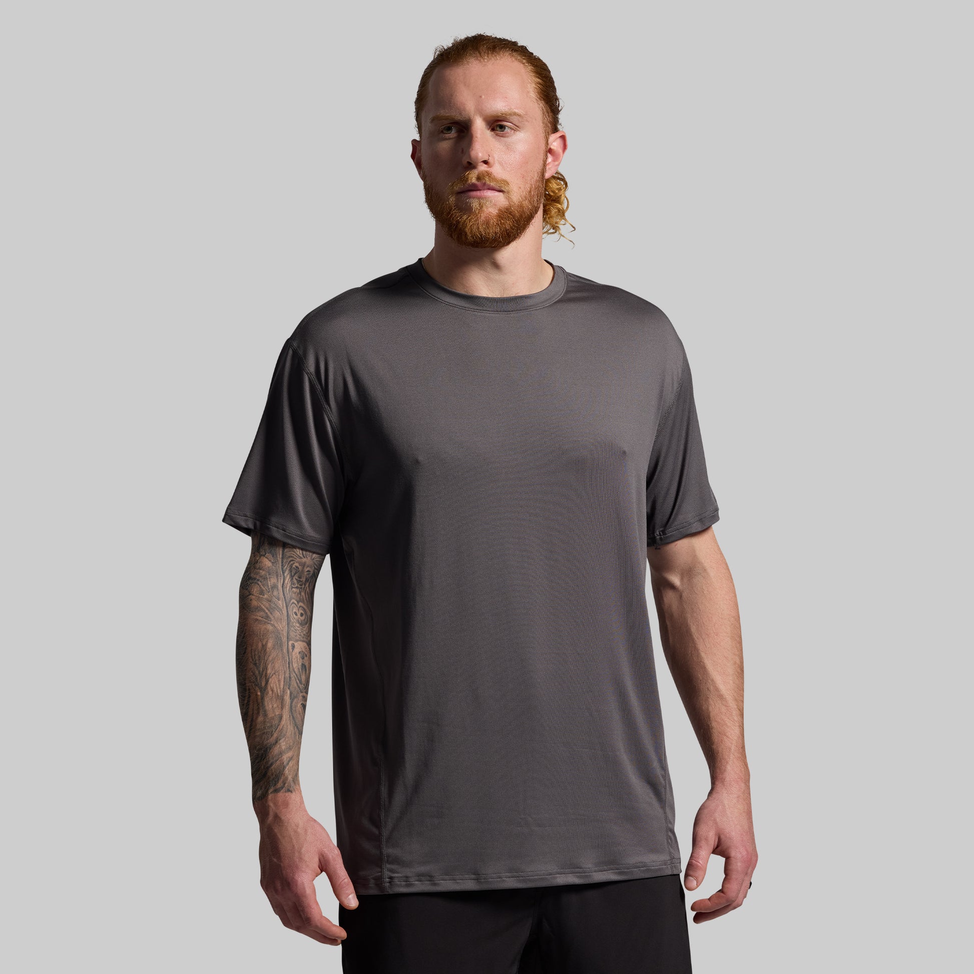Man wearing a gray t-shirt against a plain background