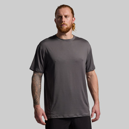 Man wearing a gray t-shirt against a plain background