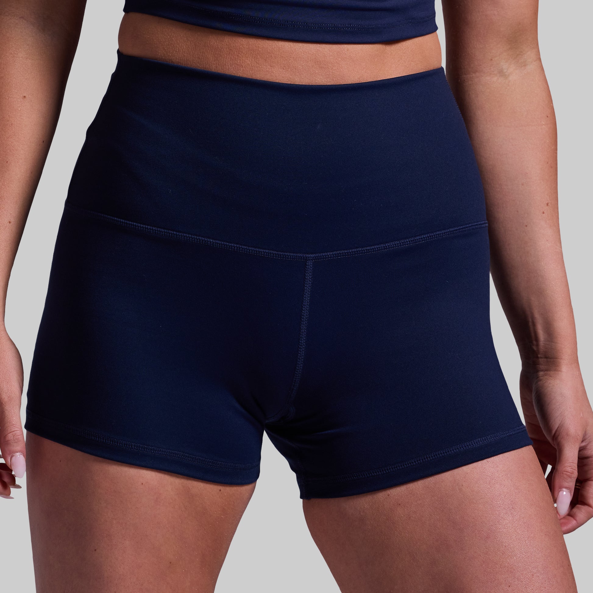 Navy blue athletic shorts worn by a person on a plain background