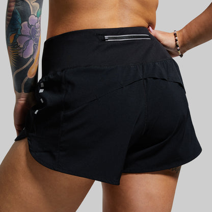 Person wearing black athletic shorts on a plain background