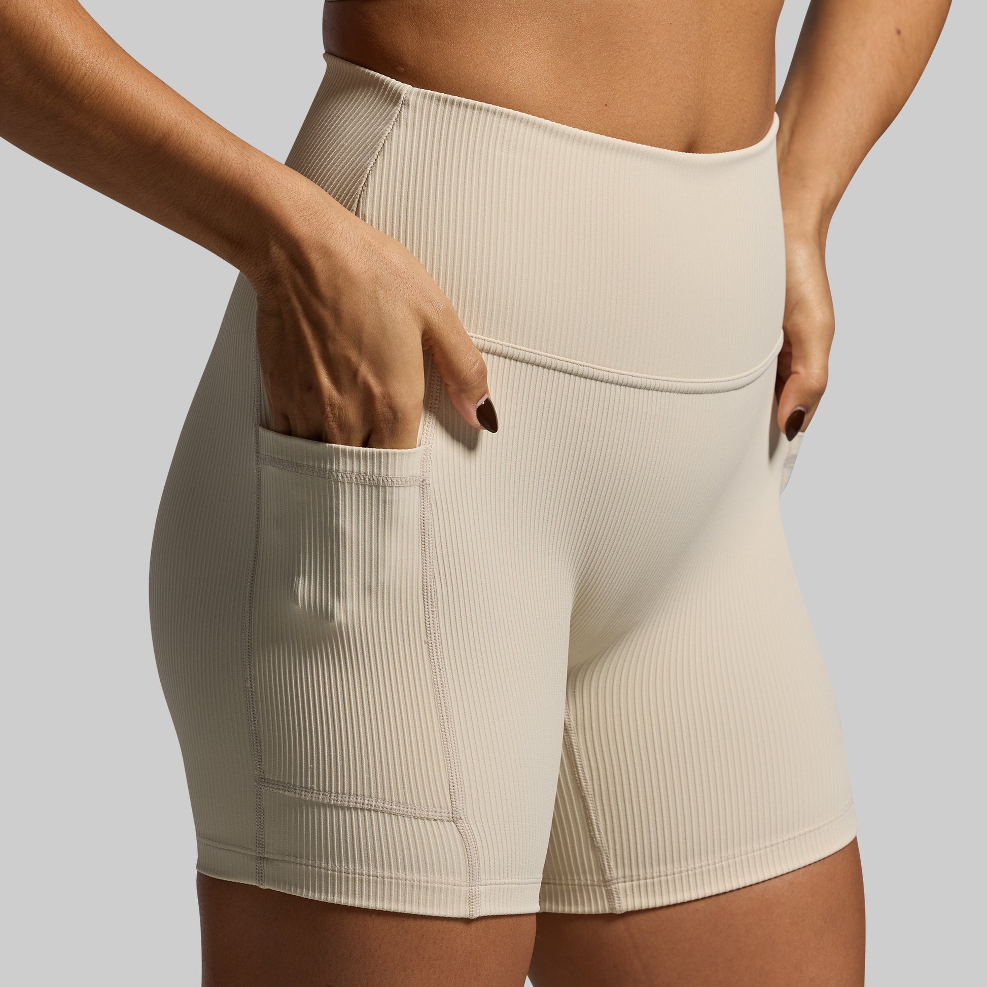 Beige ribbed shorts worn by a person on a plain background