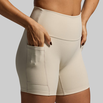 Beige ribbed shorts worn by a person on a plain background
