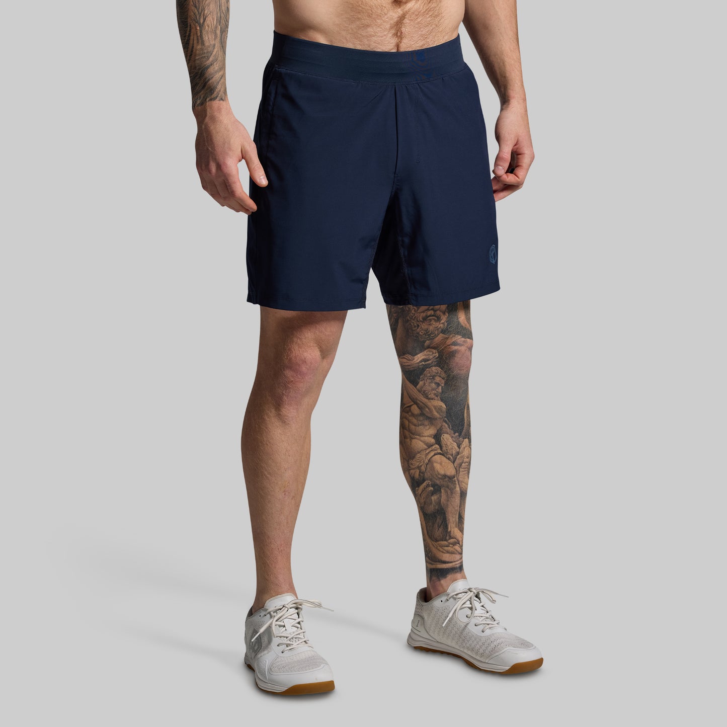 Person wearing navy shorts on a gray background