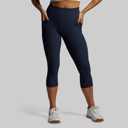 Person wearing navy blue leggings on a gray background