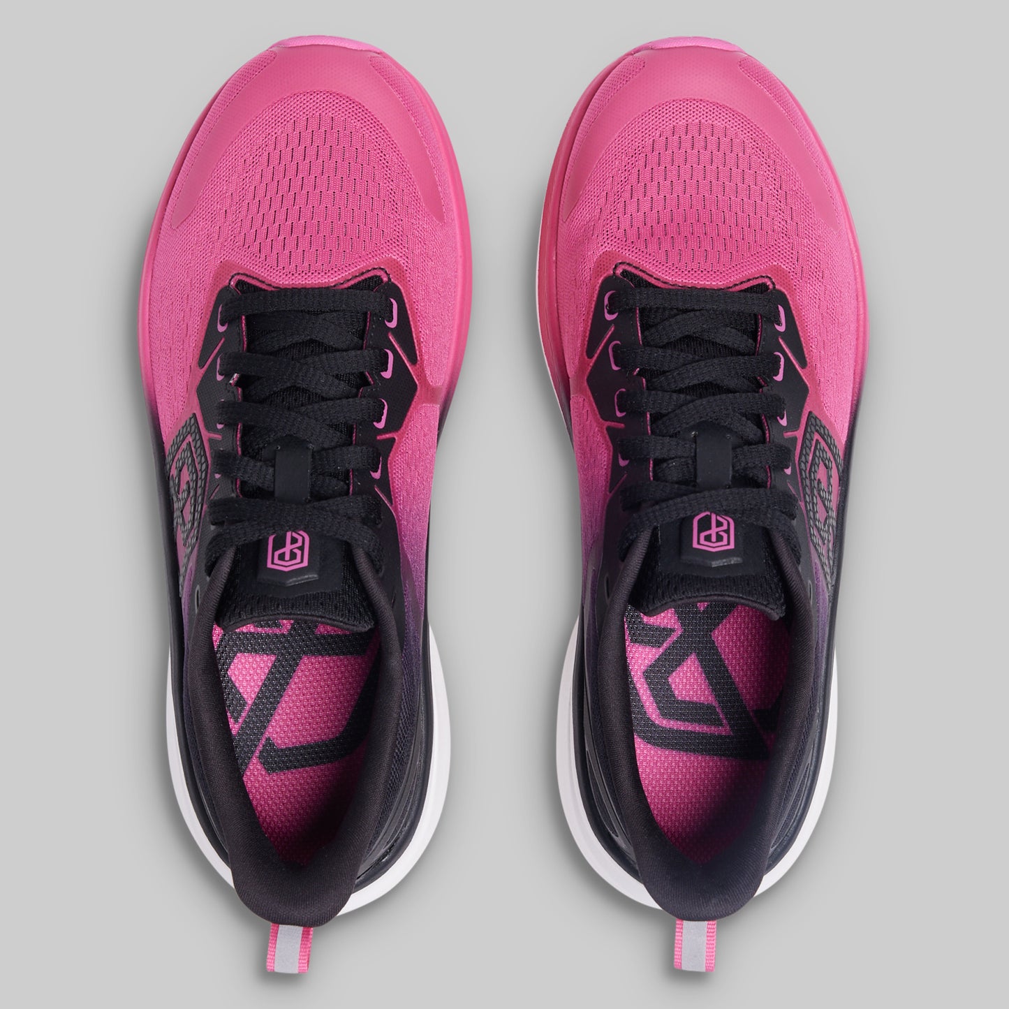 Pink and black running shoes on a gray background
