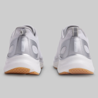 Gray athletic shoes with white soles and brown soles on a gray background