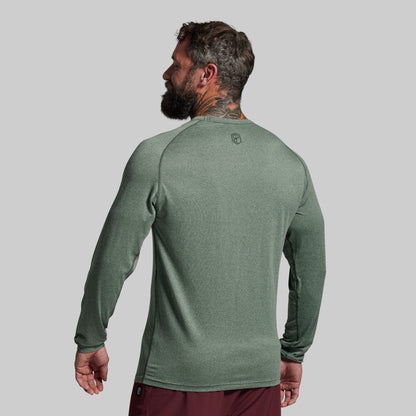 Man wearing a green long-sleeve shirt on a gray background