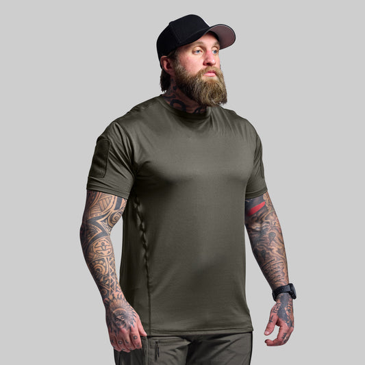 Man wearing a green t-shirt and black cap on a gray background