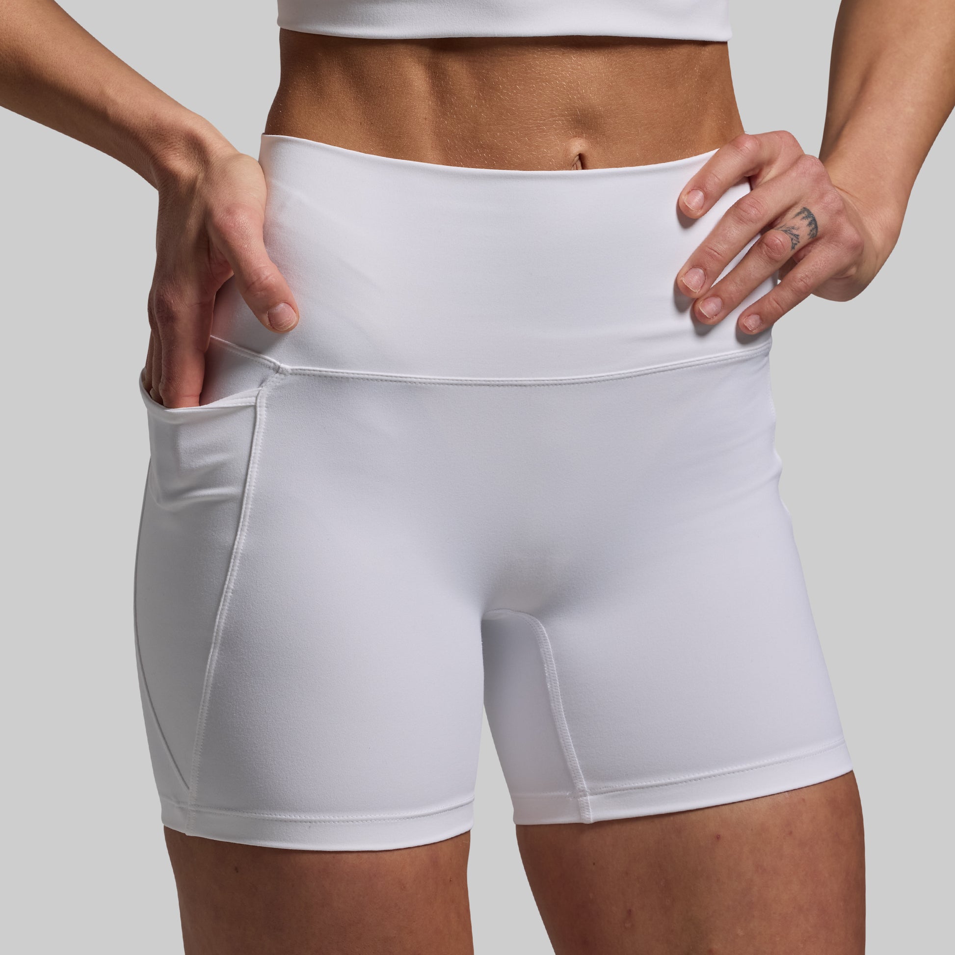 White athletic shorts worn by a person on a plain background