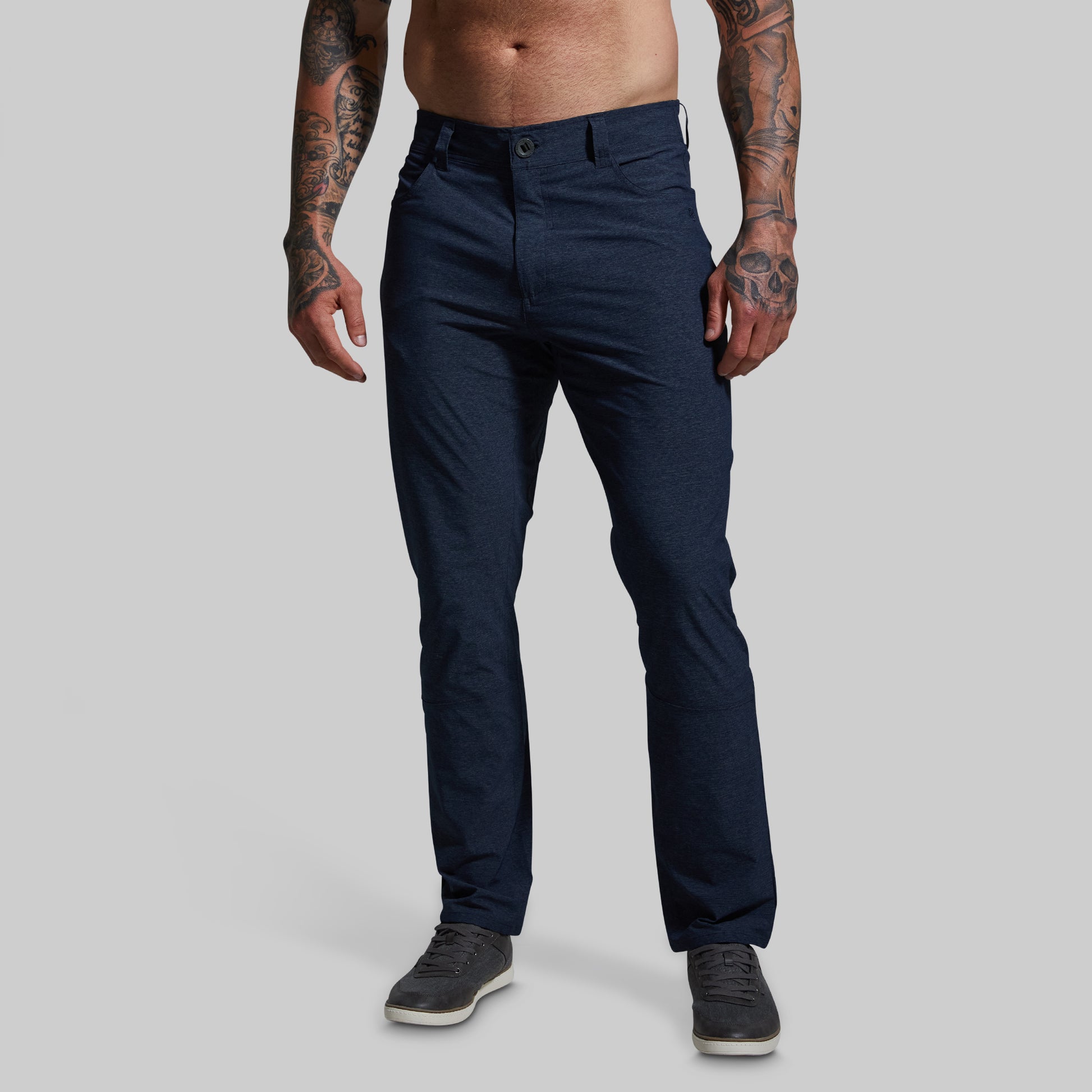 Person wearing navy blue pants on a gray background