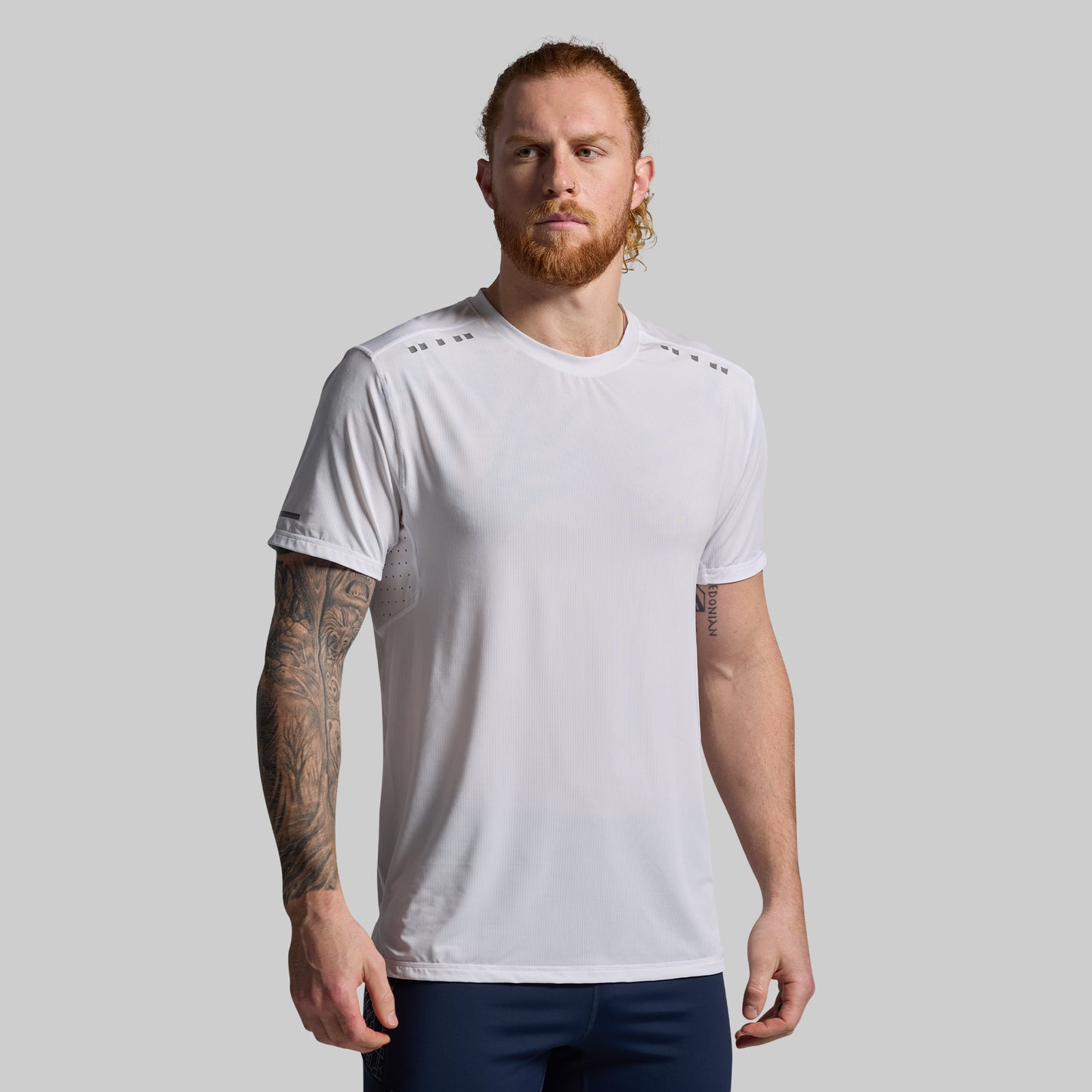Man wearing a white t-shirt with a plain background