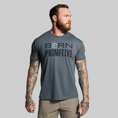 Man wearing a gray t-shirt with 'Born Primitive' text on a plain background