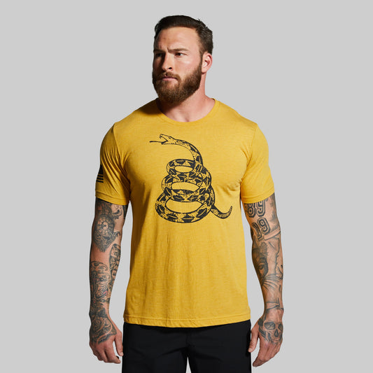 Man wearing a yellow t-shirt with a snake design on a gray background