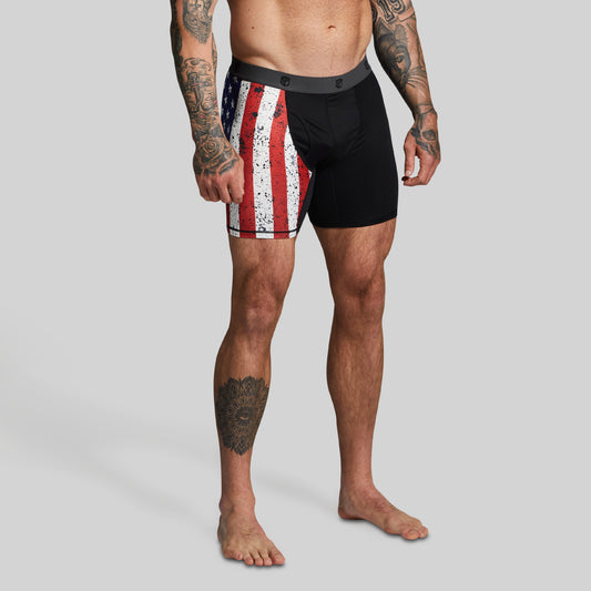 Man wearing black boxer briefs with American flag pattern on right leg.