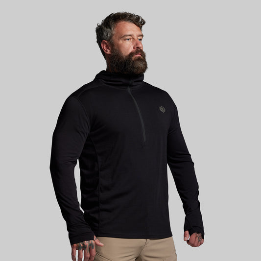 Man wearing a black long-sleeve shirt with a logo on a gray background