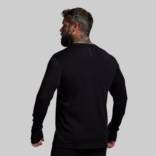 Man wearing a black long-sleeve shirt on a gray background