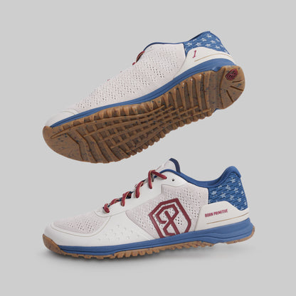 White athletic shoes with blue and red accents on a gray background