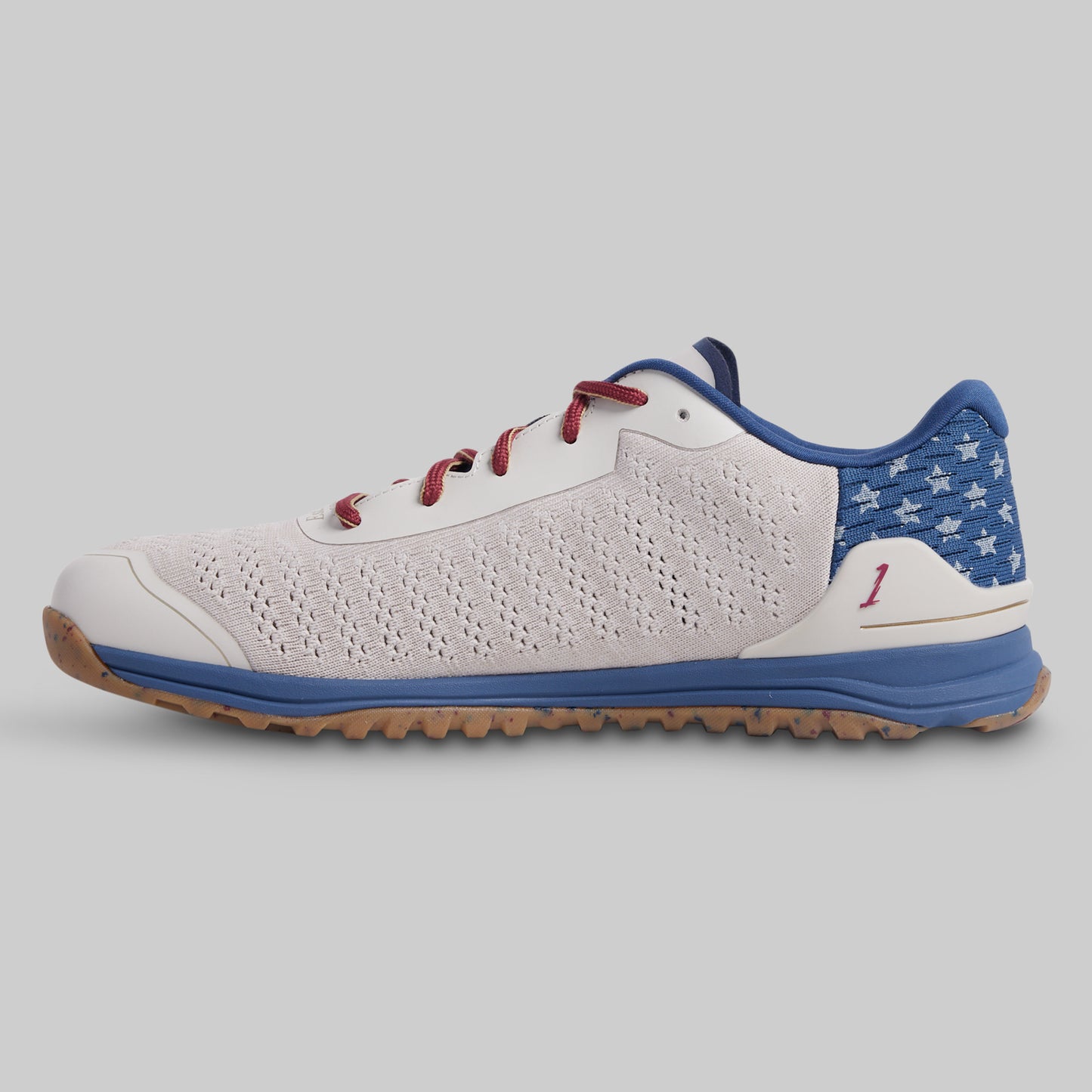 White and blue sneaker with red accents on a gray background
