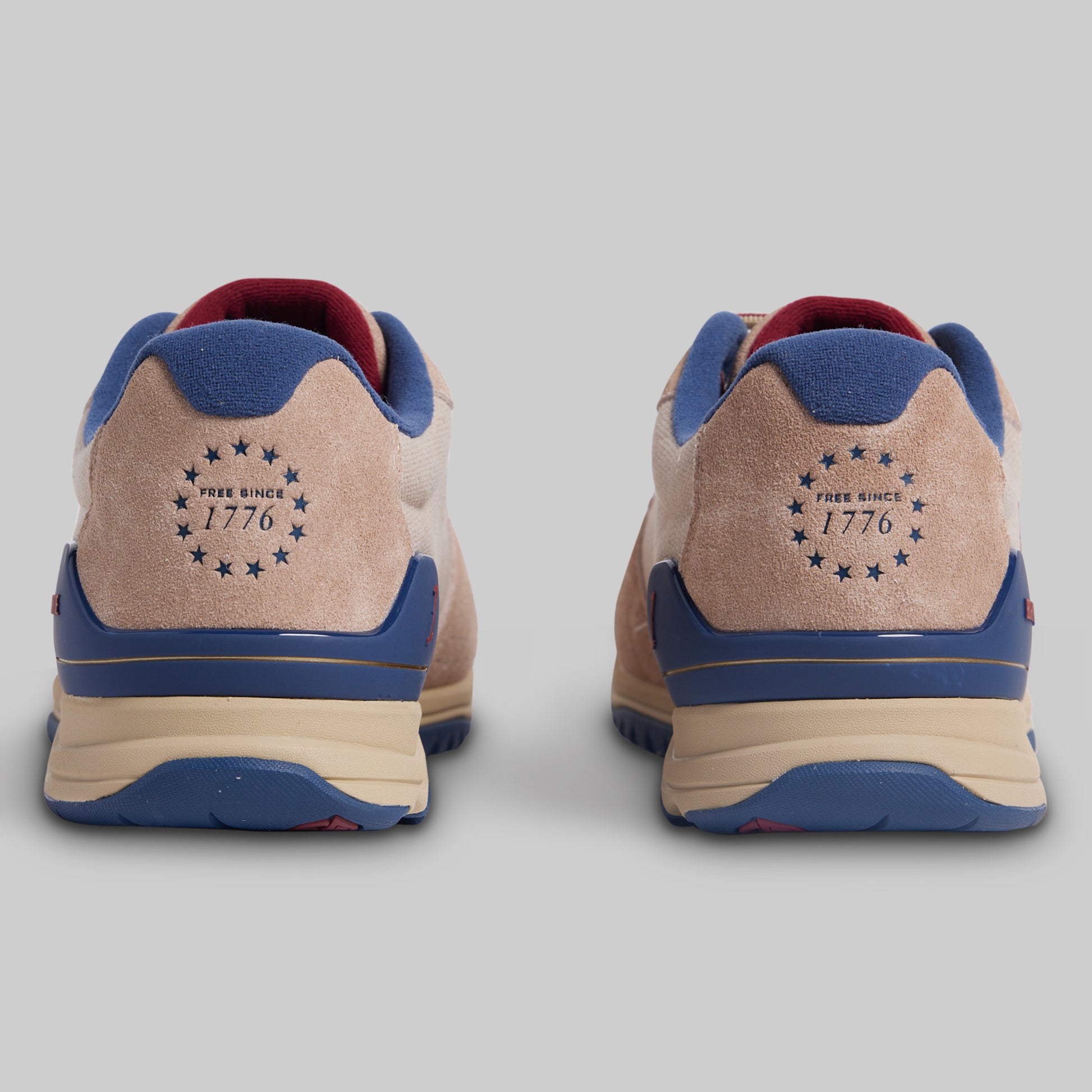 Pair of sneakers with 'Free Since 1776' logo on a gray background