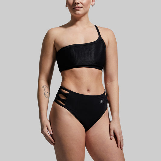 Person wearing a black bikini against a plain background