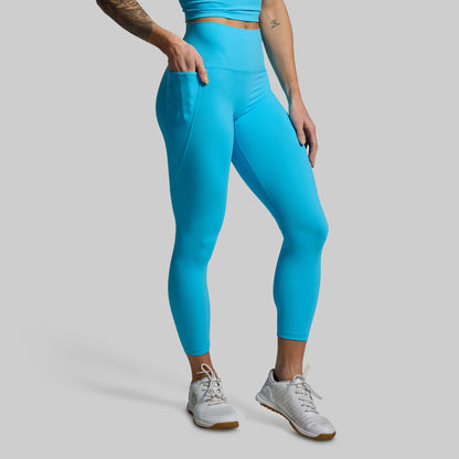 Person wearing bright blue leggings on a gray background