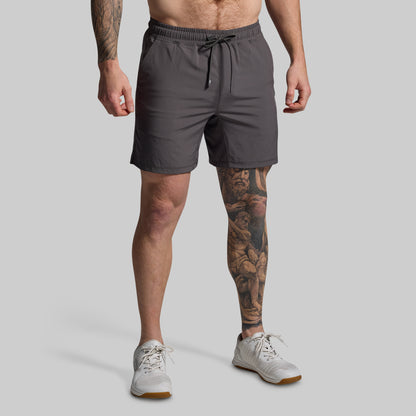 Man wearing gray shorts on a plain background