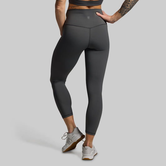 Person wearing gray leggings on a gray background