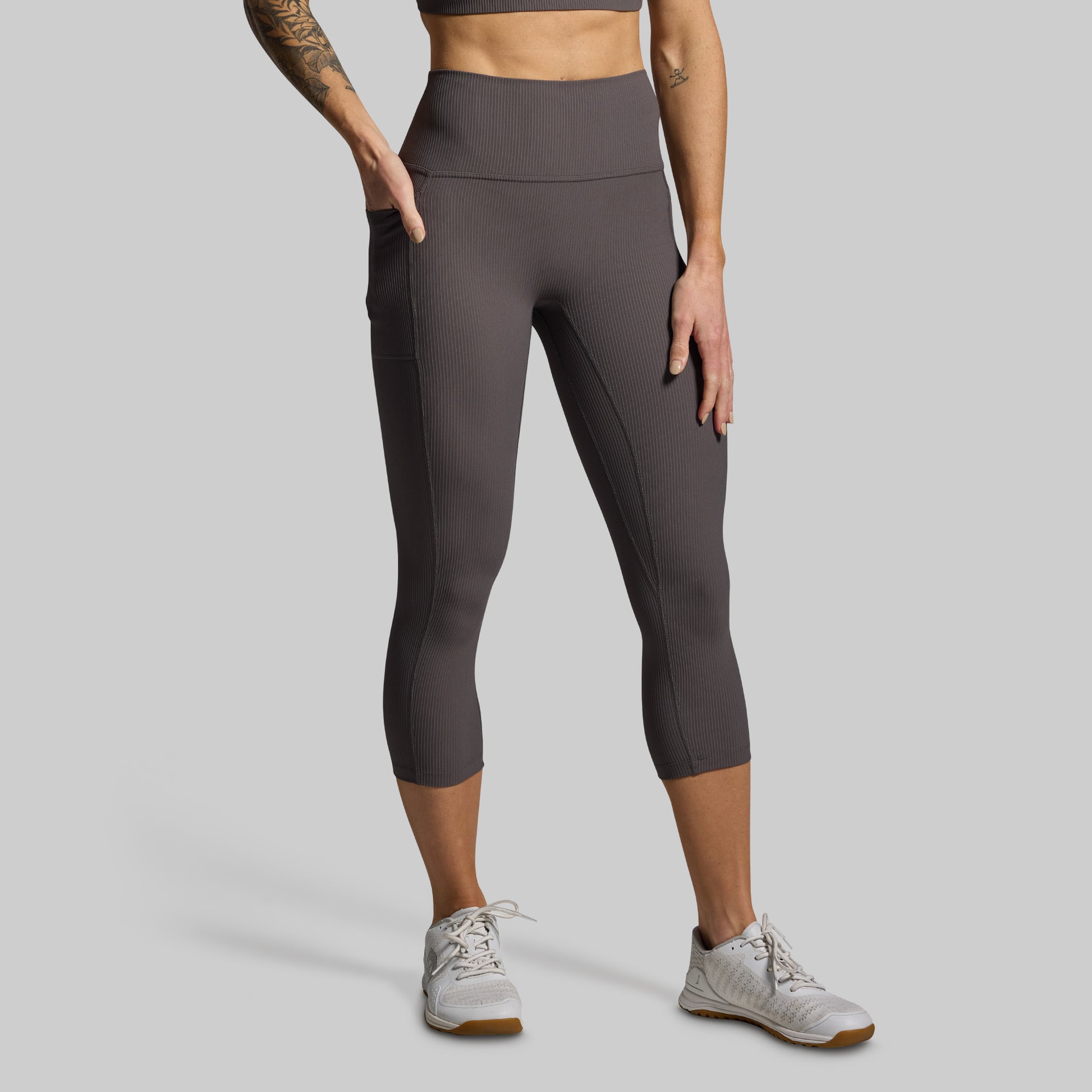 Person wearing gray leggings on a gray background
