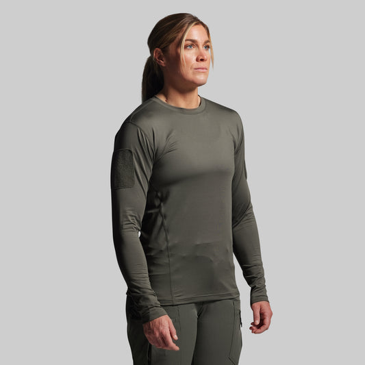 Person wearing a green long-sleeve shirt and pants on a gray background